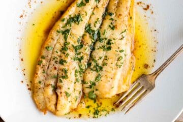 A fillet of fish meunière with a fork.