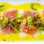 A few slices of raw tuna topped with olives, lemon, pistachios and olive oil.