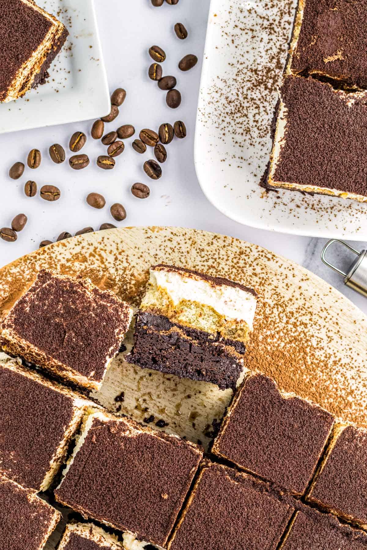 A platter of tiramisu brownies with one turned on it's side to reveal the layers.