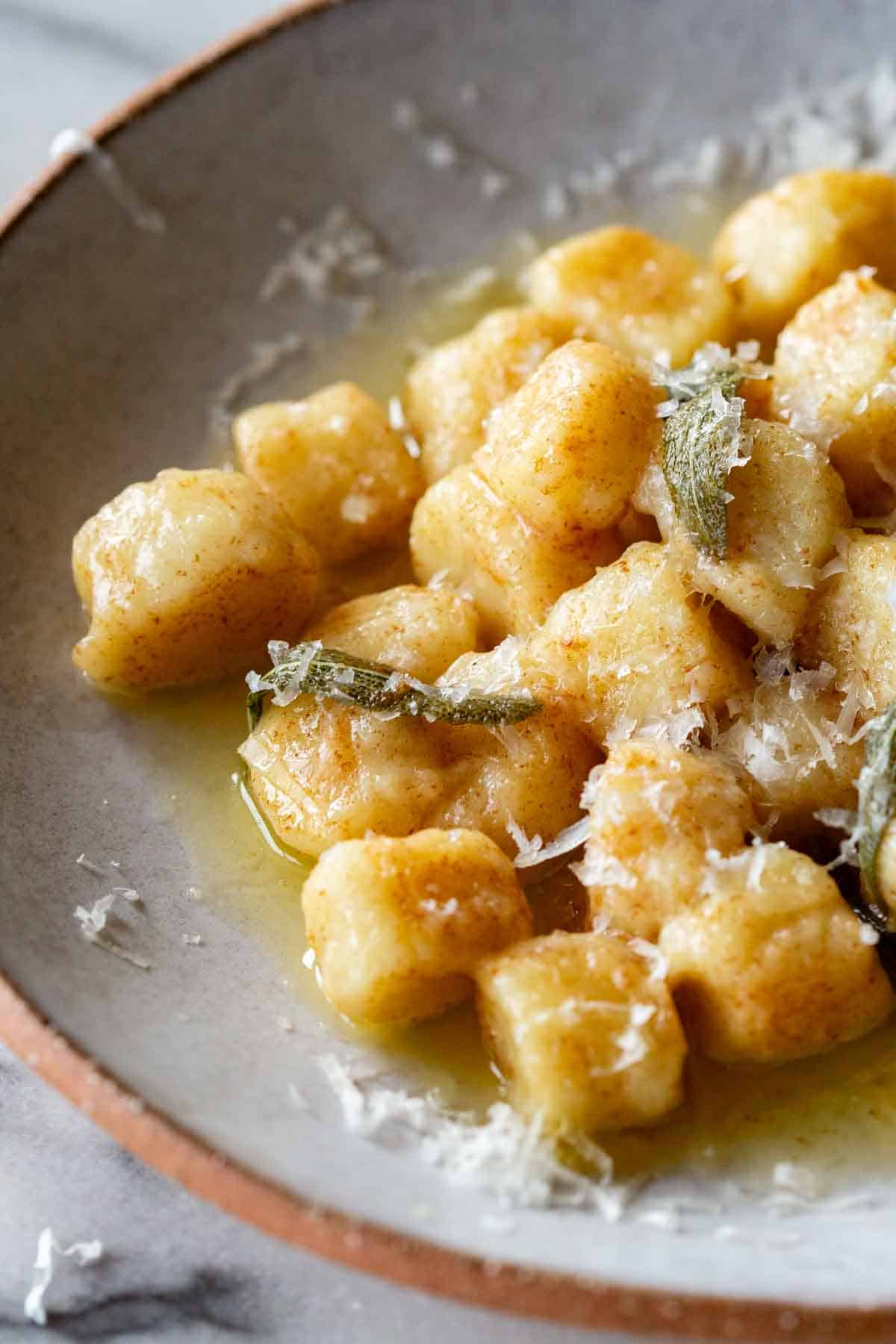 Gnocchi in a sage brown butter sauce with grated parmesan on top.