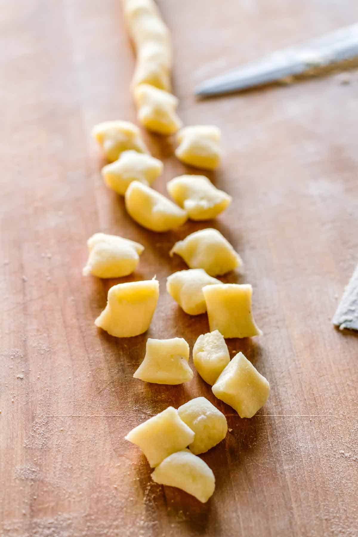 Potato gnocchi being cut into pieces.