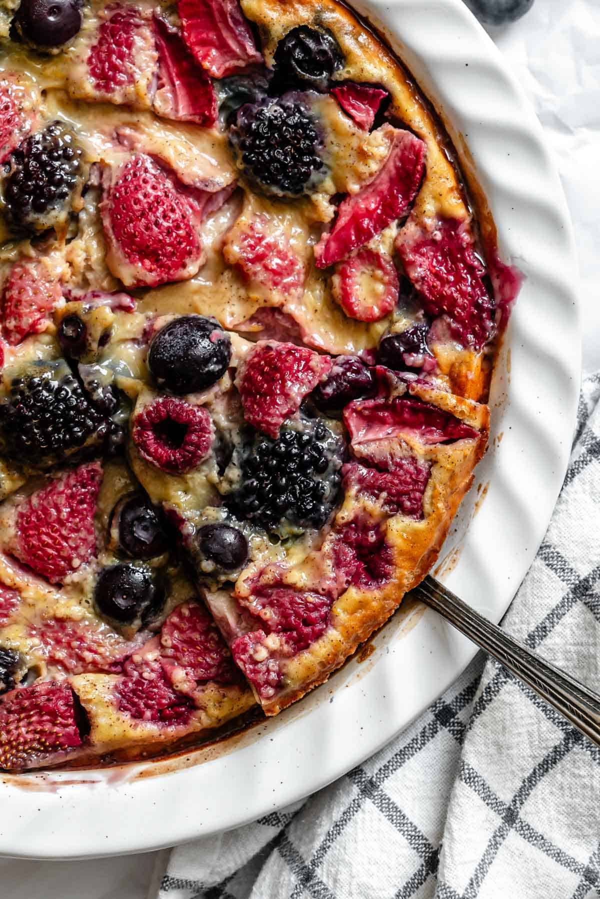 Close-up of berry clafoutis showing the berries baked into the custard filling.
