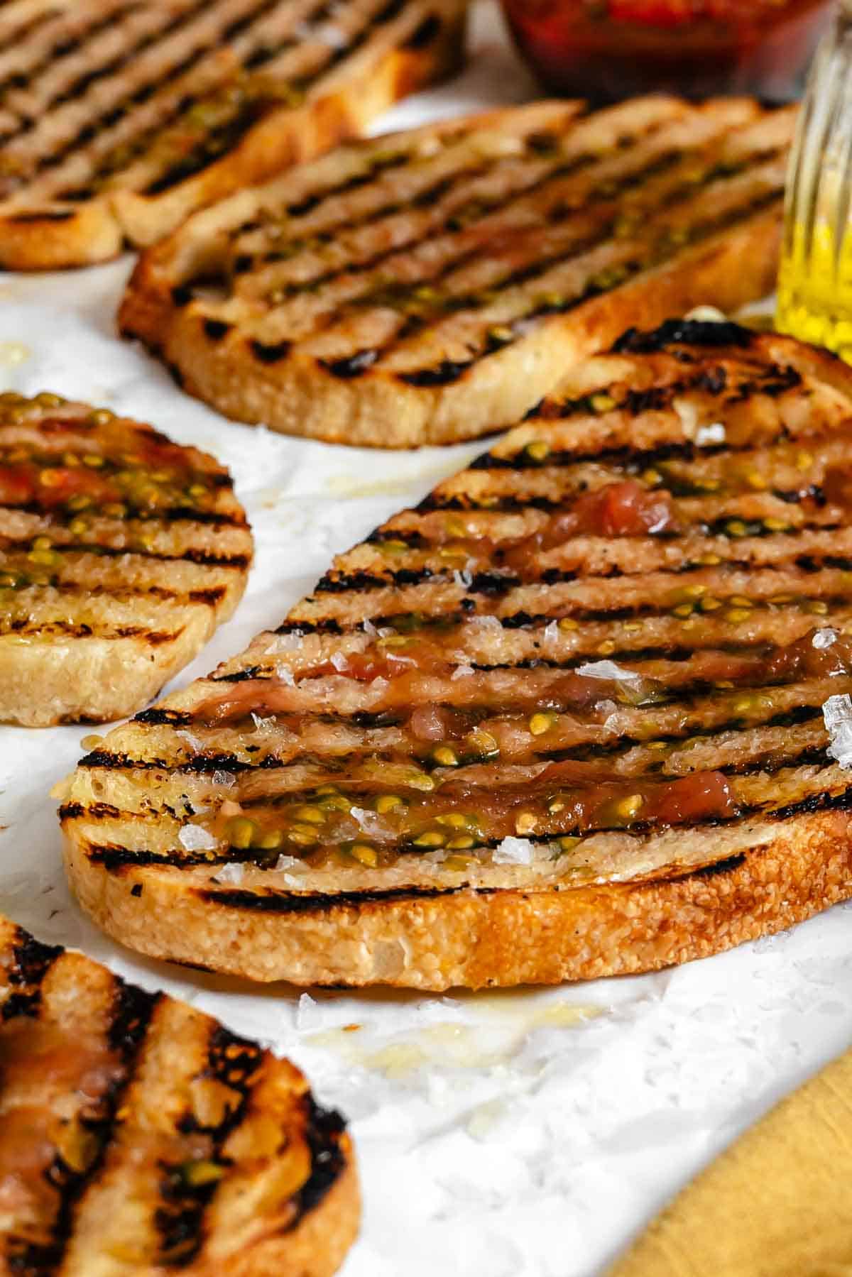 Close-up detail of pan con tomate, showing the texture of the bread and the juices from the tomato topping.