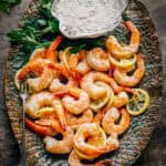 A platter of roasted shrimp cocktail with lemon mustard sauce.
