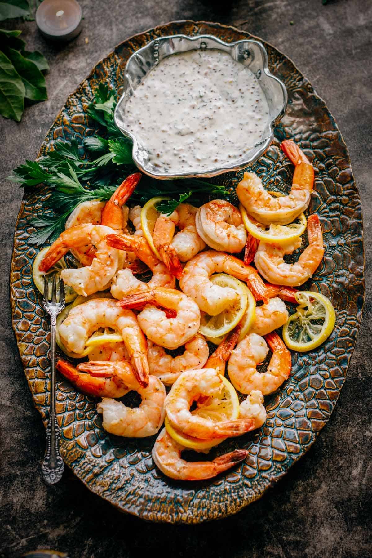 A platter of roasted shrimp cocktail with lemon mustard sauce.