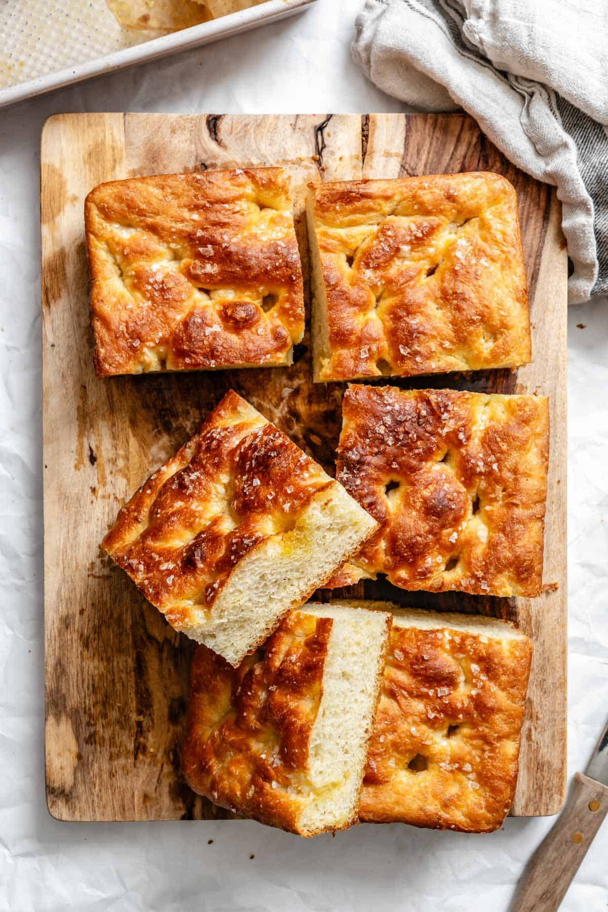 Close-up of cut focaccia bread squares showing fluffy interior crumb structure and crispy golden crust.