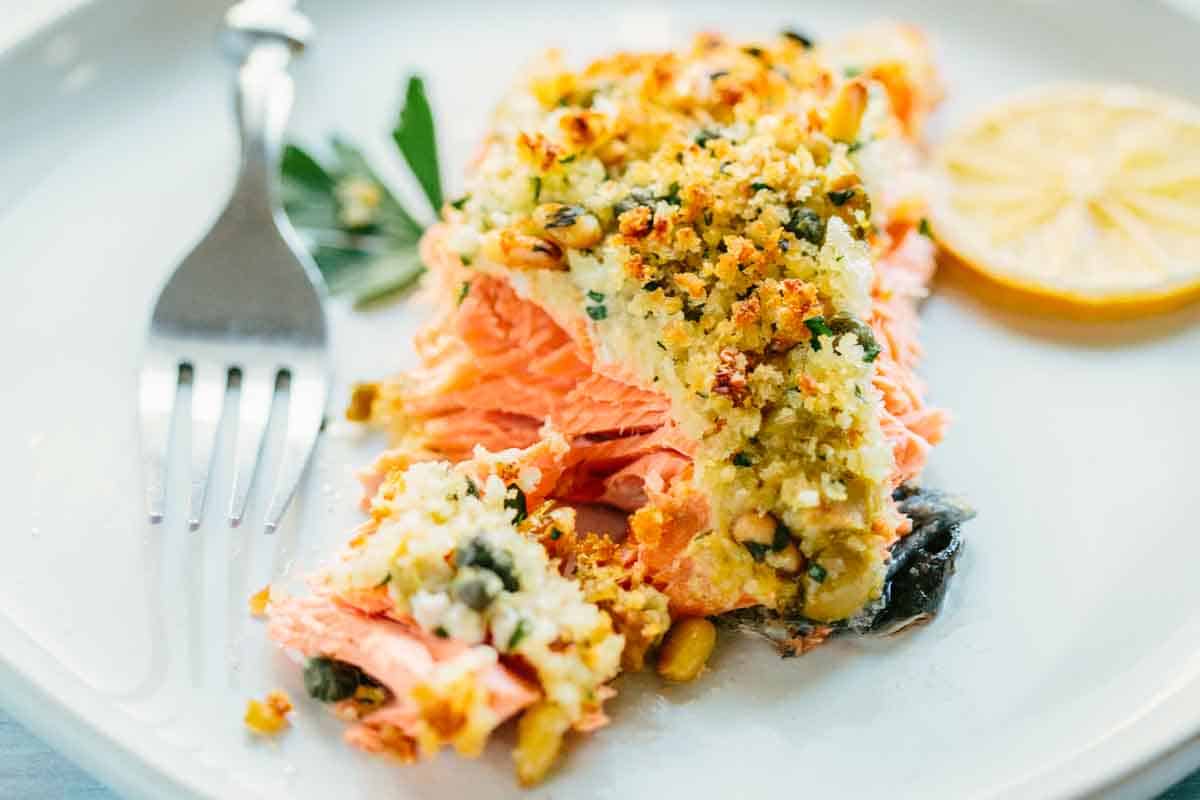 Cross-section view showing the flaky interior of the salmon contrasting with the crispy breadcrumb topping. The moist coral-colored fish flakes beautifully while the golden crust maintains its texture.