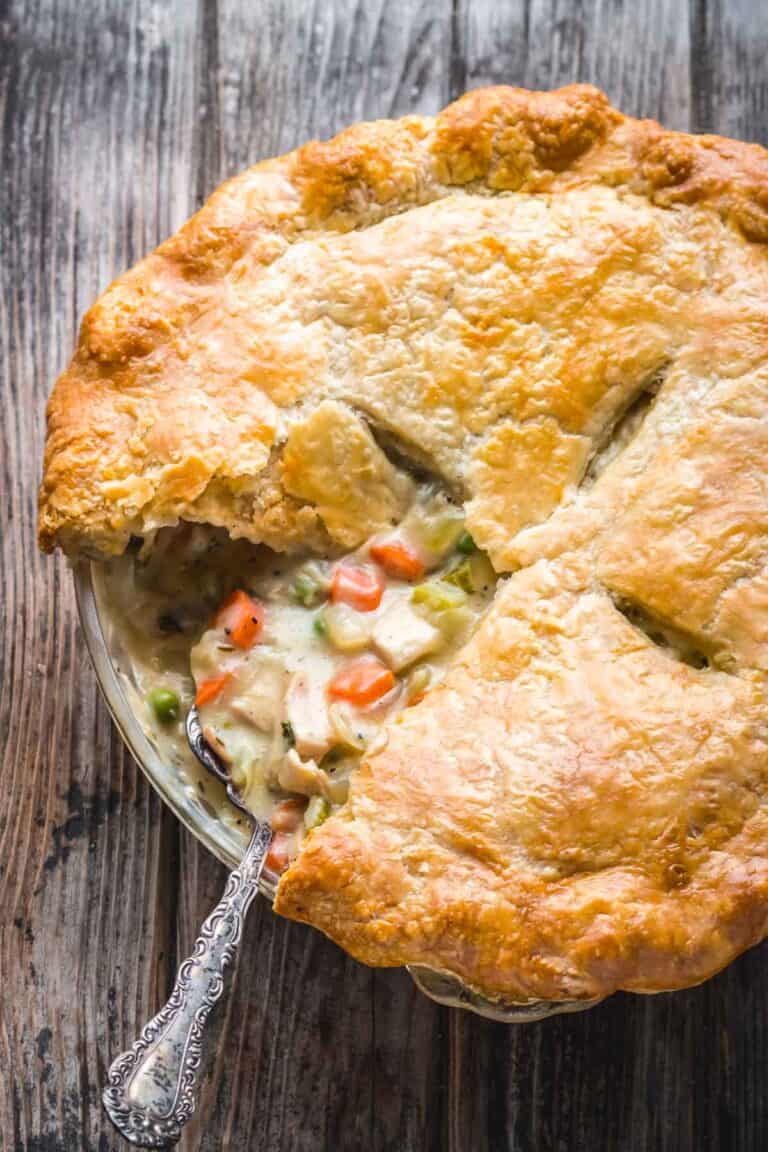 Overhead shot of the chicken pot pie with a golden crust that has a slice missing.