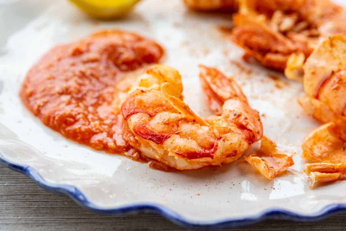 Close-up of a single shrimp coated in Old Bay seasoning, highlighting the texture of the shell and seasoning.