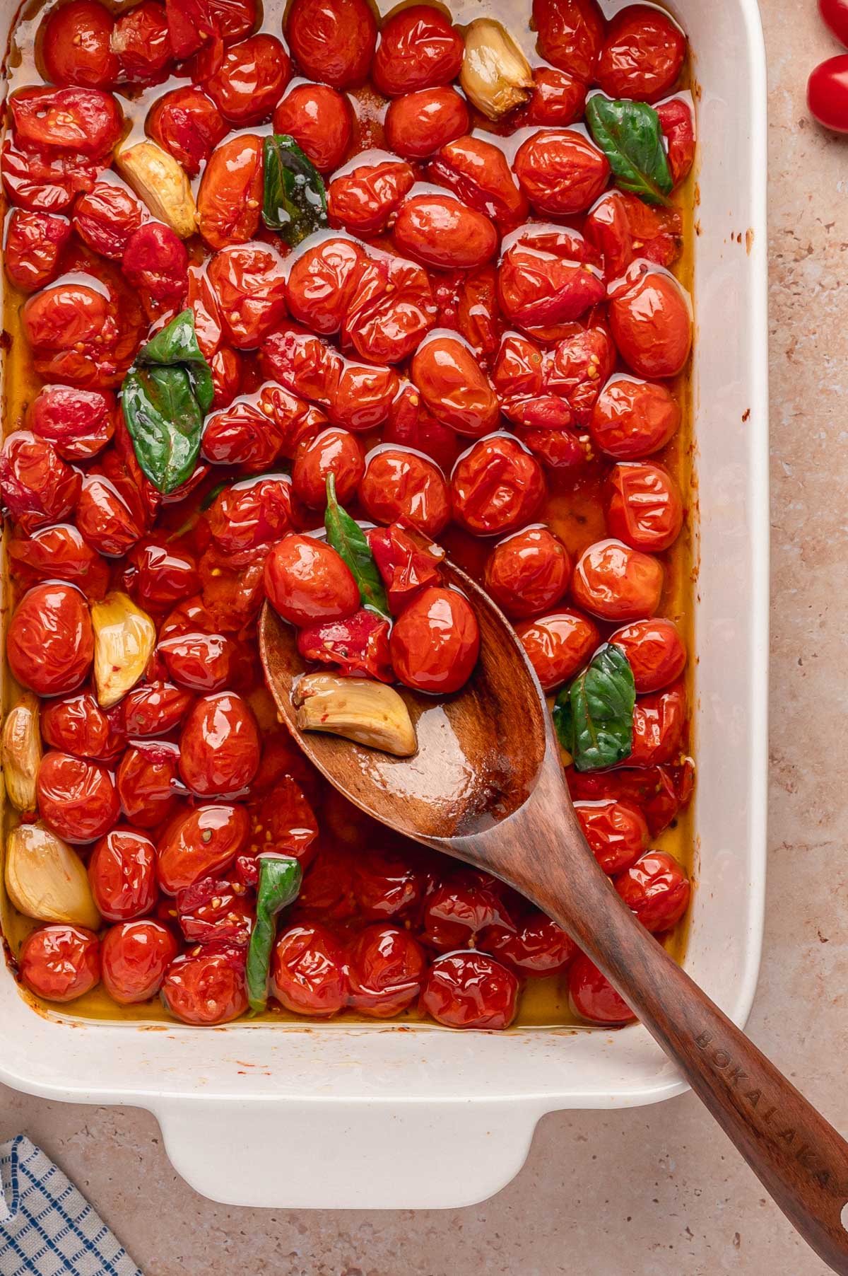 Close-up of tomato confit being scooped with a wooden spoon.