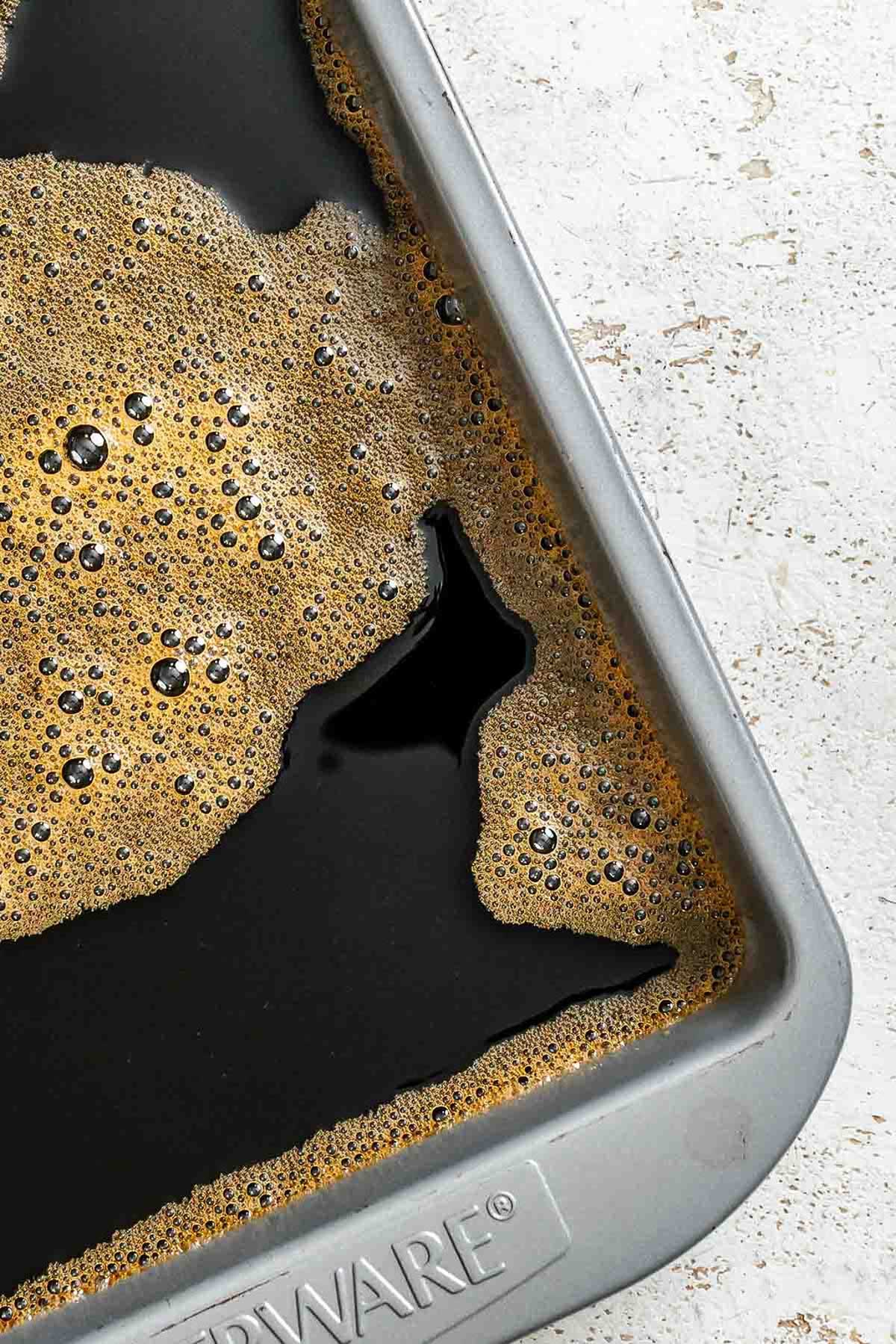 Coffee mixture poured into a shallow metal baking pan, ready to freeze.