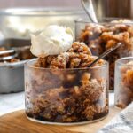 Several glasses of Sicilian coffee granita with whipped cream, with the pan in the background.
