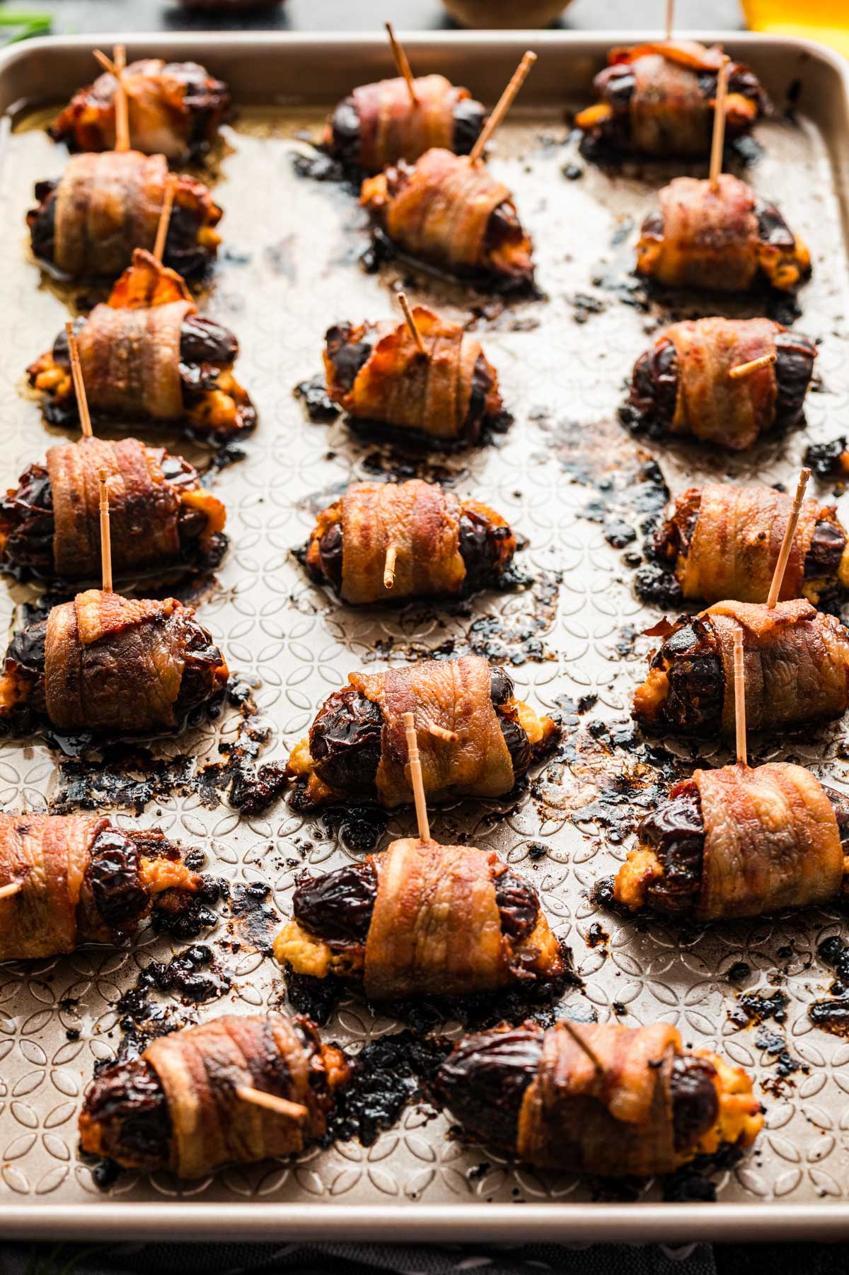 Close-up of baked bacon-wrapped dates showing golden, crispy bacon and caramelized edges.