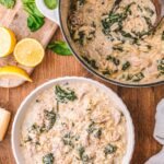 Chicken Florentine soup served in a white bowl with orzo, chicken, spinach, and Parmesan on top.