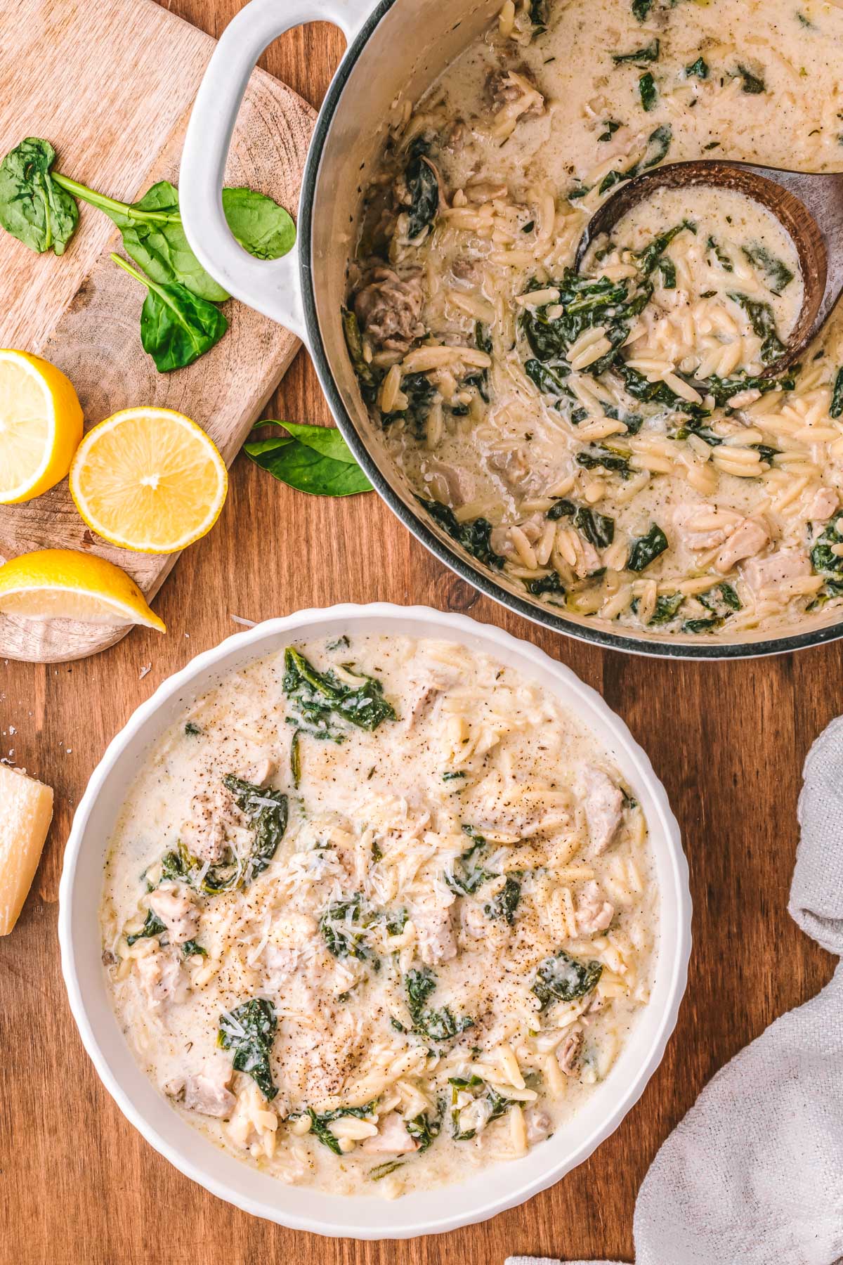 Chicken Florentine soup served in a white bowl with orzo, chicken, spinach, and Parmesan on top.