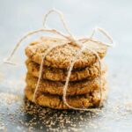 Stack of ginger molasses cookies tied with twine, dusted with sugar for gifting or holiday presentation.