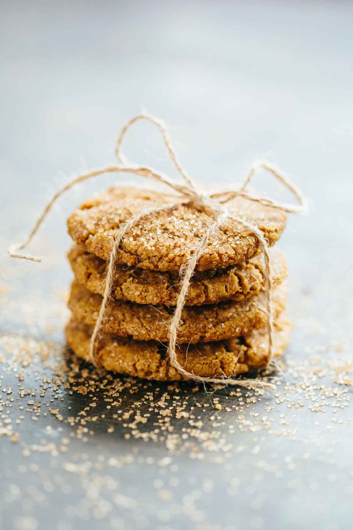 Stack of ginger molasses cookies tied with twine, dusted with sugar for gifting or holiday presentation.