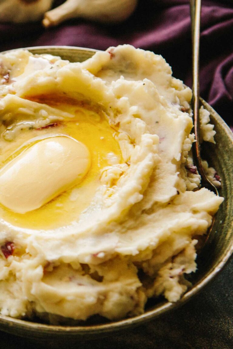 Side view of red skin mashed potatoes showing smooth, creamy texture and glossy butter.