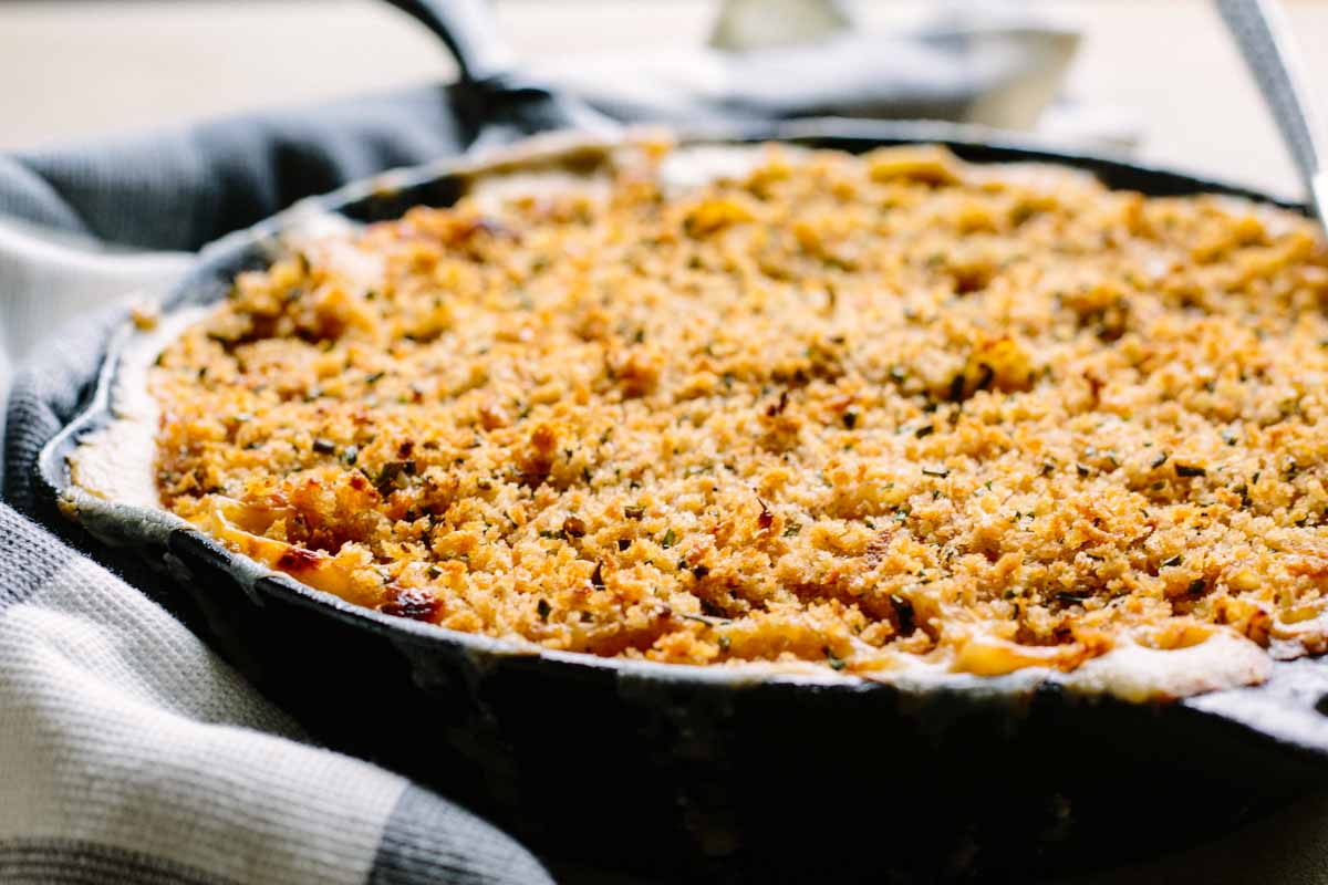 Close-up of baked skillet mac and cheese with a golden brown panko breadcrumb crust.
