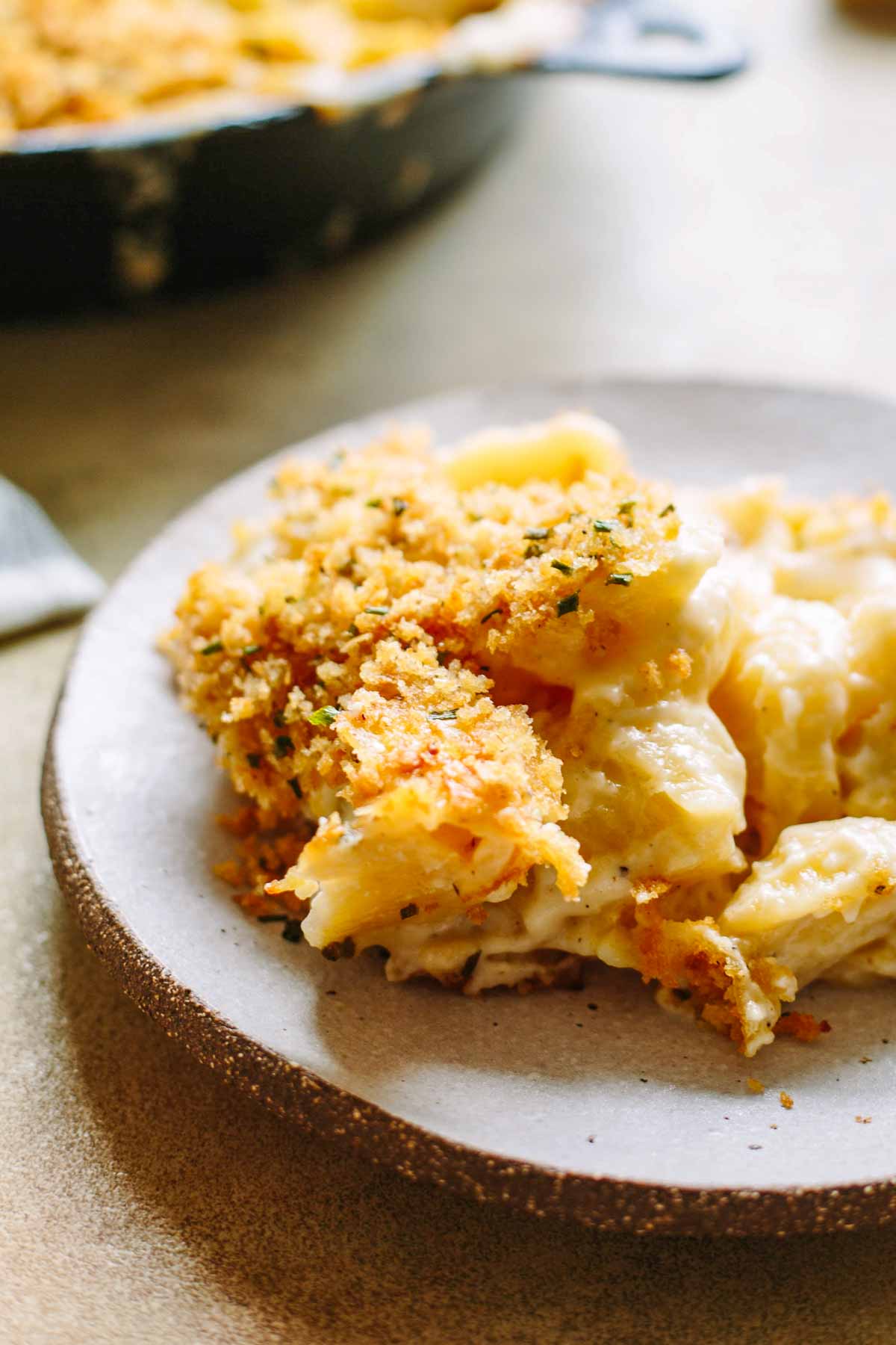 Creamy baked macaroni and cheese with crispy breadcrumb topping served on a ceramic plate.