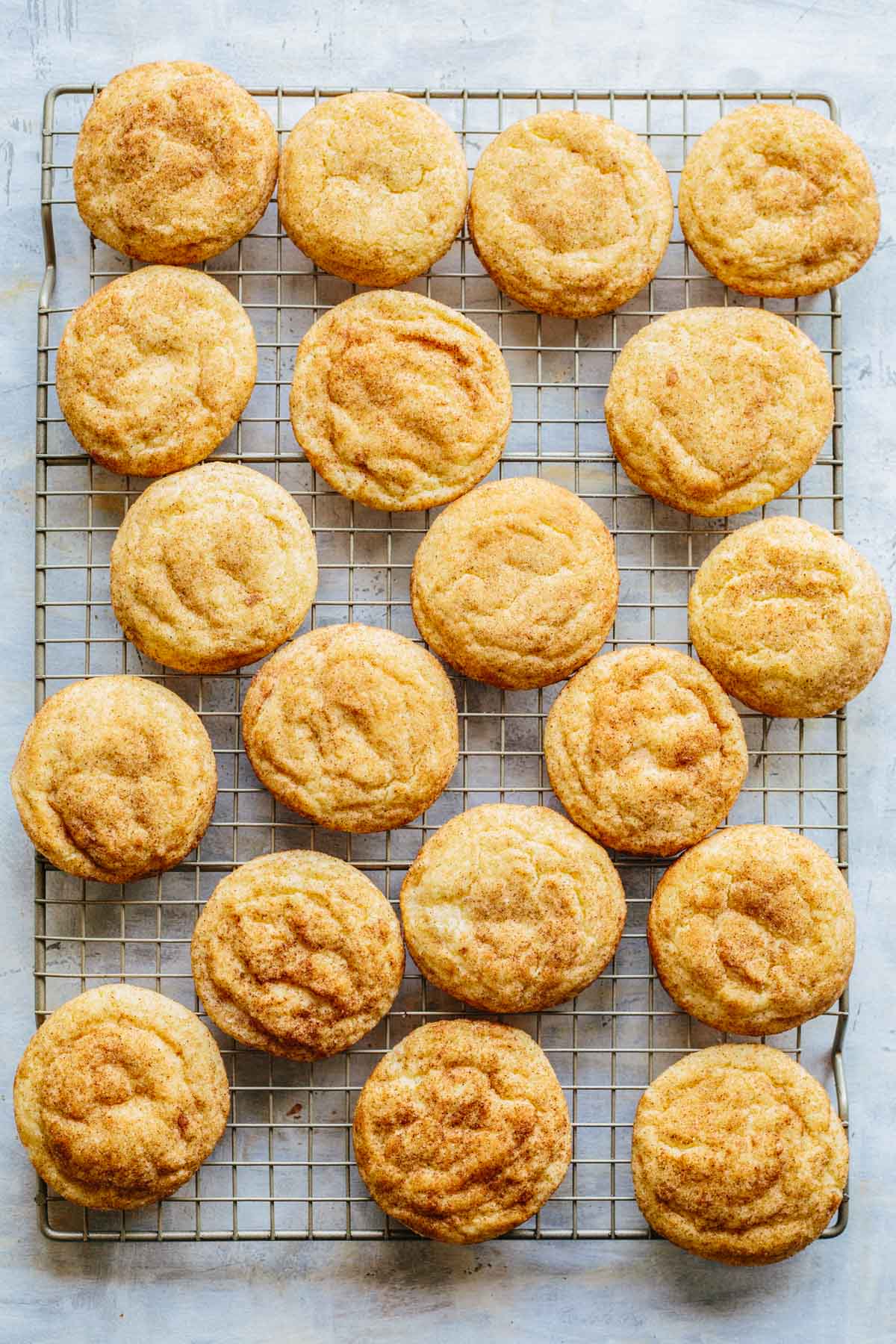 Overhead view of golden brown chai snickerdoodles cooling on a wire rack.