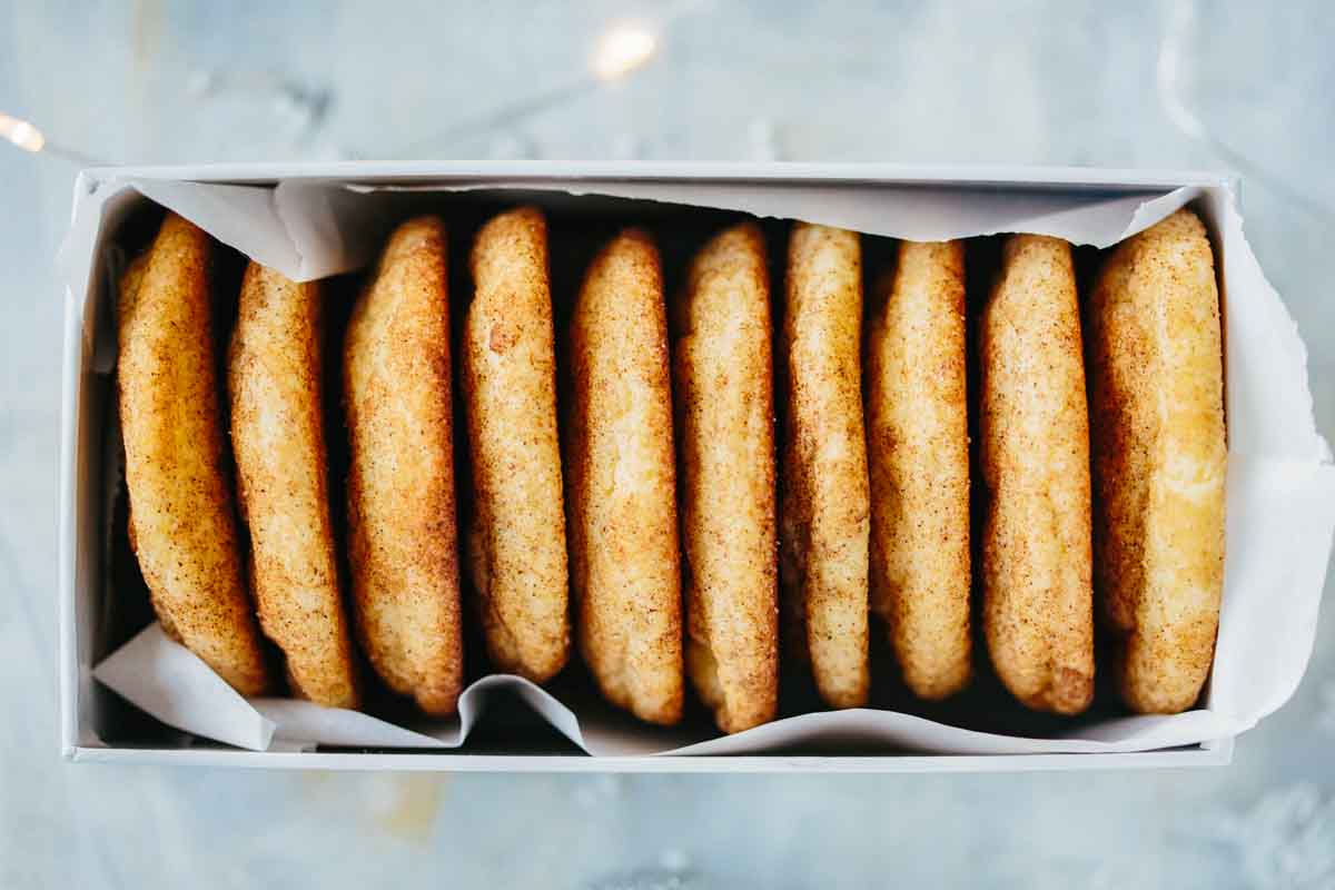 Box filled with perfectly aligned chai snickerdoodles lined with parchment paper for gifting.