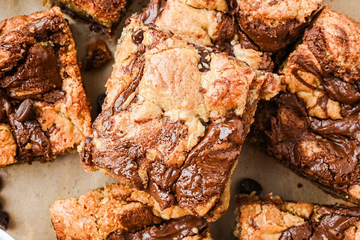 Overhead shot of multiple blondie squares highlighting their marbled Nutella tops and golden edges.
