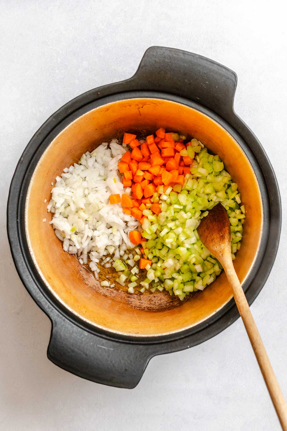 Diced onions, carrots and celery added to a Dutch oven with olive oil before cooking.