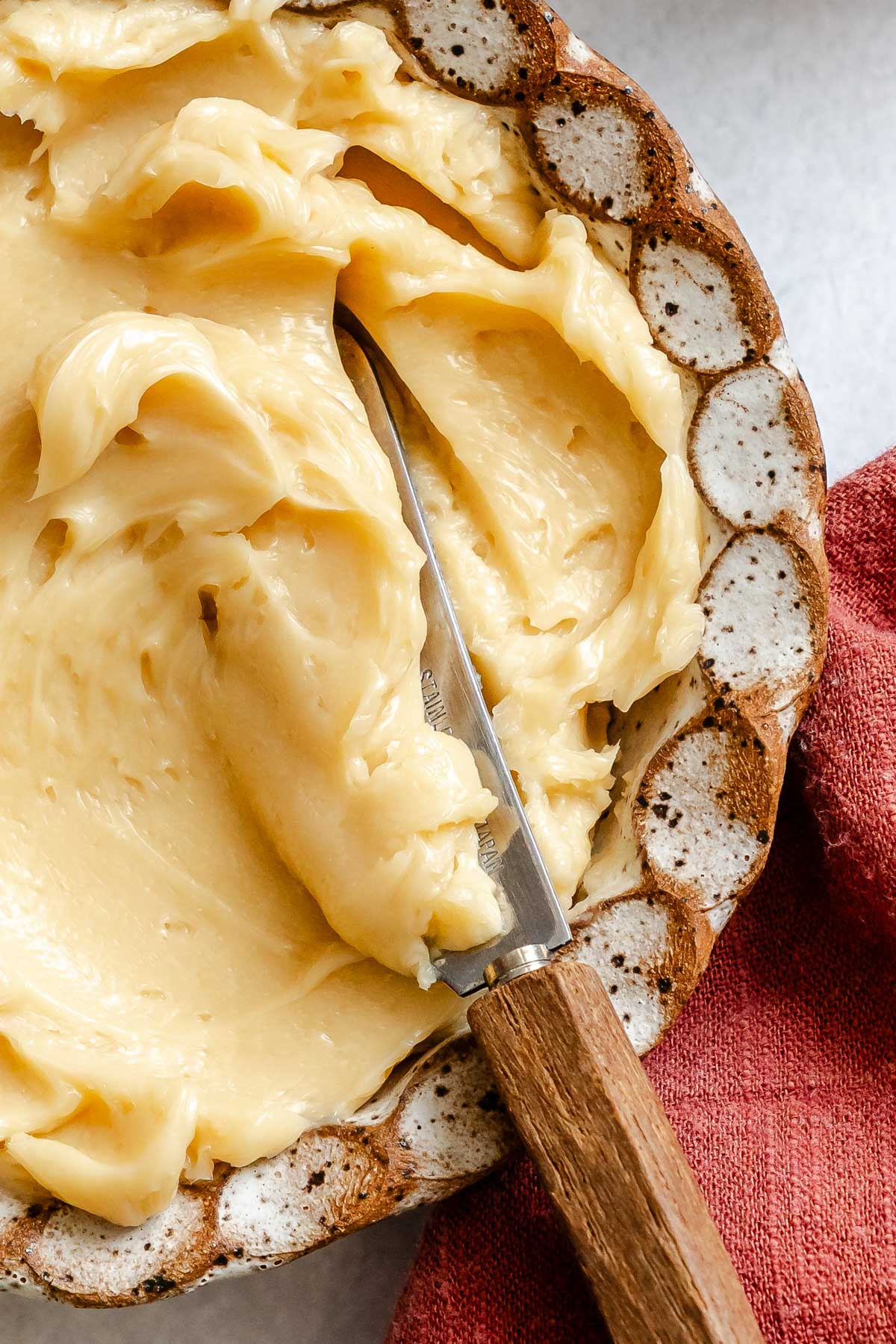 Detailed close-up of whipped maple butter showing soft folds and a creamy consistency in a patterned bowl.