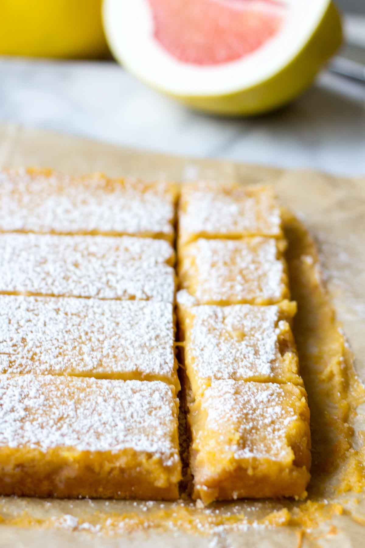 Close up of sliced grapefruit bars showing the smooth citrus curd layer and shortbread crust.