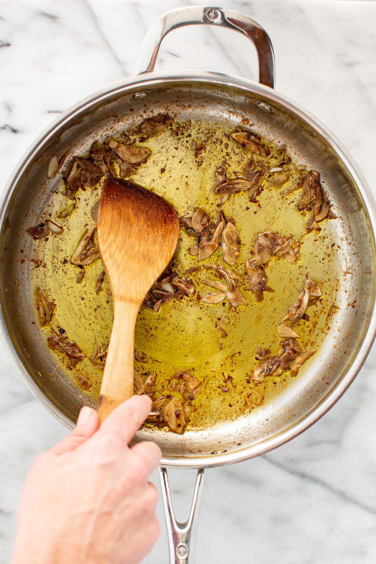 Garlic and anchovies cooked in olive oil until softened and broken down, stirred with a wooden spoon.