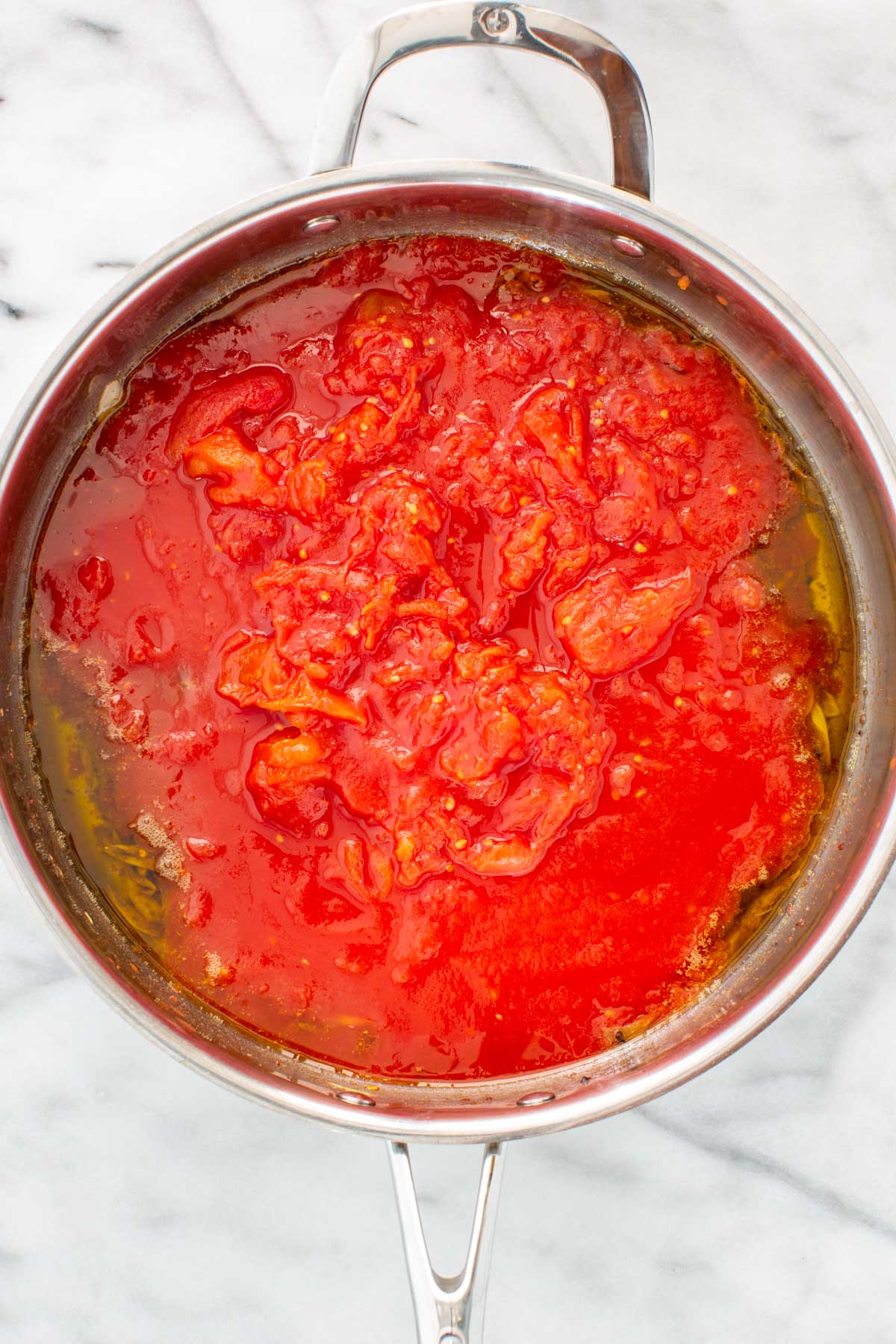 Crushed tomatoes added to the pan with the garlic and anchovy oil to start the puttanesca sauce.