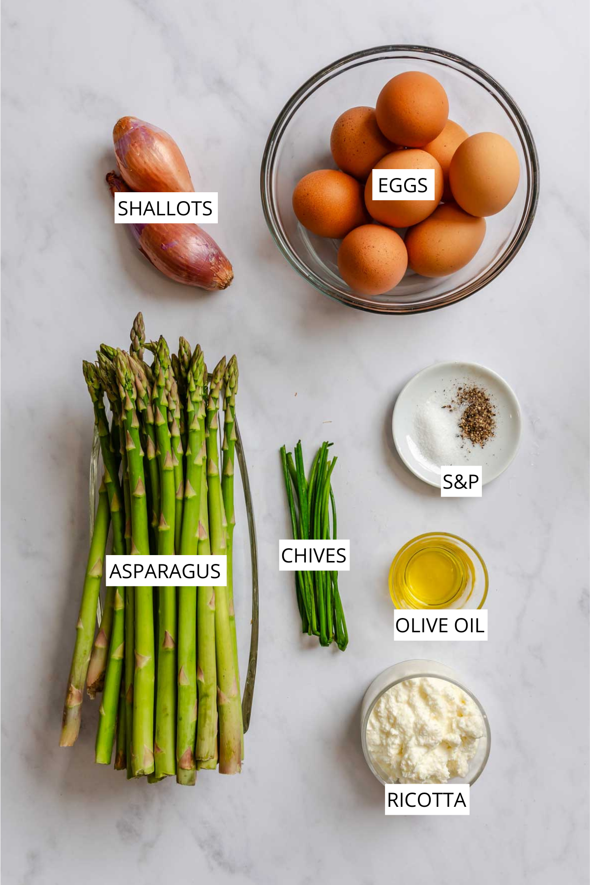 Labeled ingredients of frittata like eggs, shallots, asparagus, chives, ricotta, olive oil.