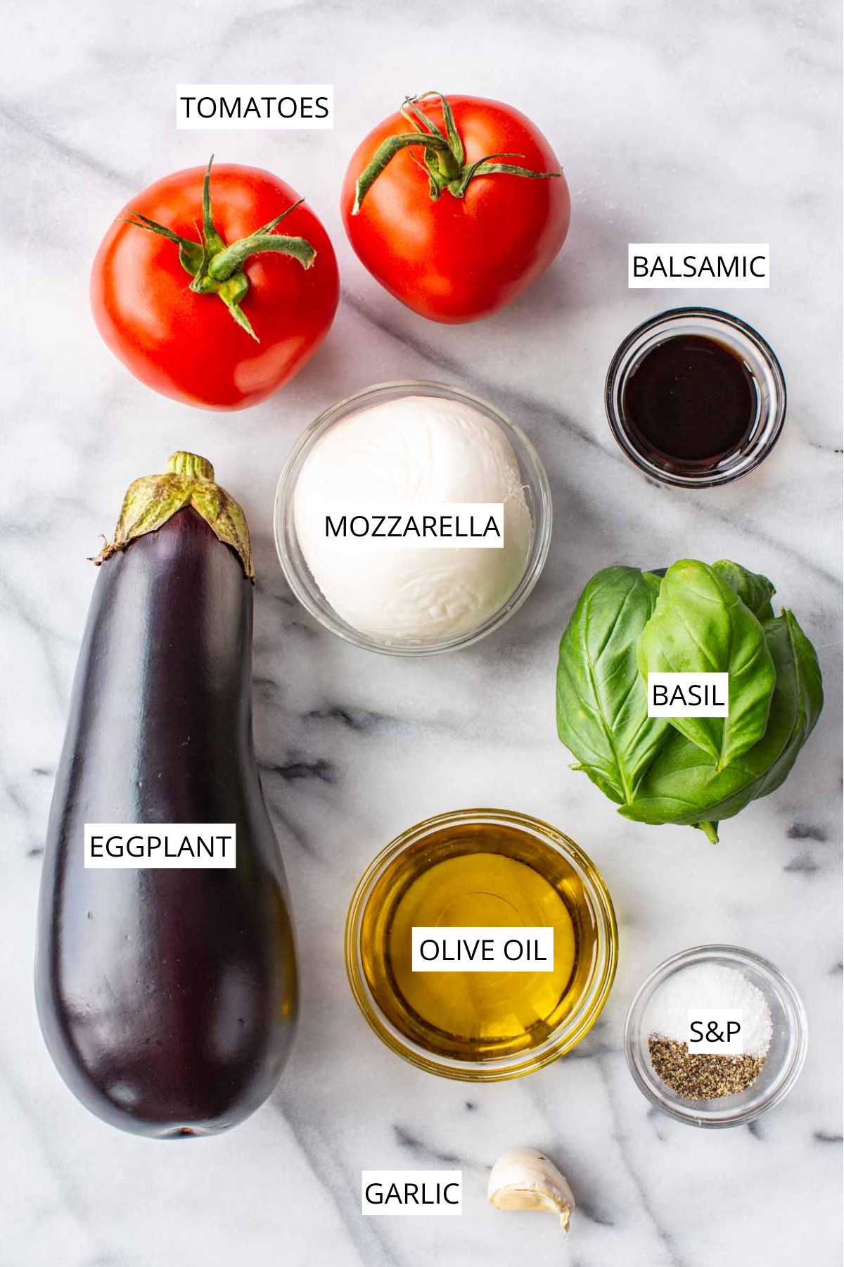 Labeled ingredients for eggplant caprese: tomatoes, mozzarella, eggplant, basil, balsamic, olive oil, garlic, and salt & pepper.